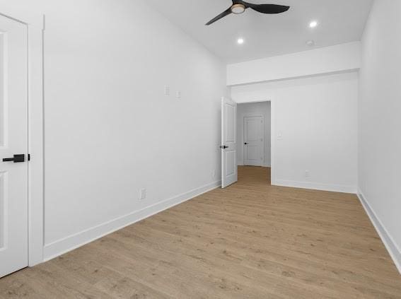 spare room featuring light wood-type flooring, baseboards, a ceiling fan, and recessed lighting