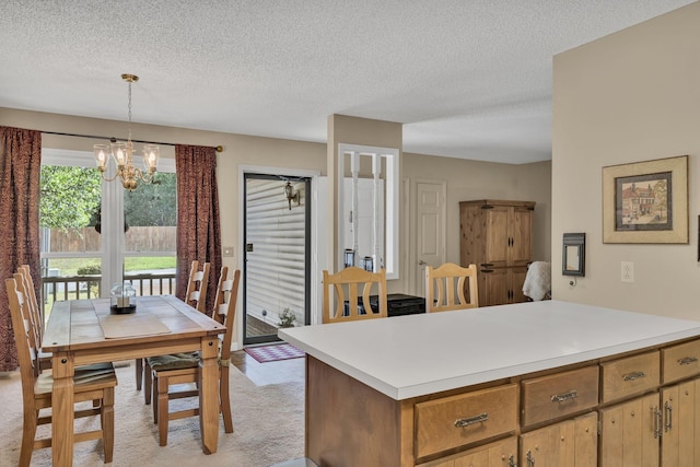 kitchen featuring pendant lighting, a notable chandelier, light carpet, and a textured ceiling