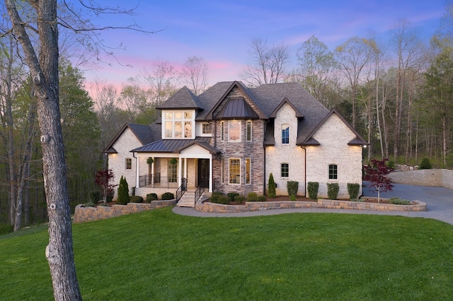 view of front facade with a lawn and covered porch