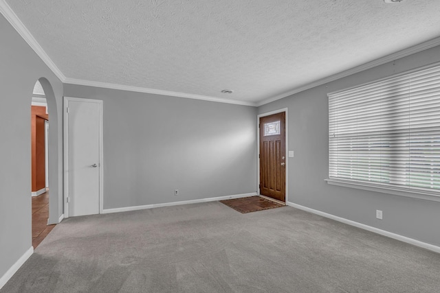 interior space featuring a textured ceiling, light colored carpet, and crown molding