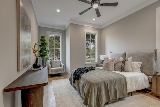 bedroom featuring ceiling fan, crown molding, and light hardwood / wood-style floors