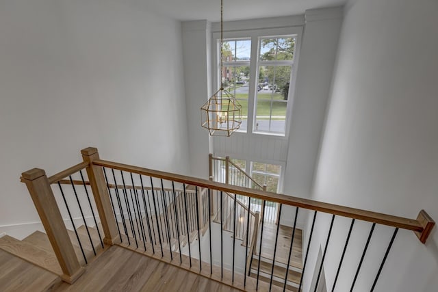 staircase featuring an inviting chandelier and hardwood / wood-style floors