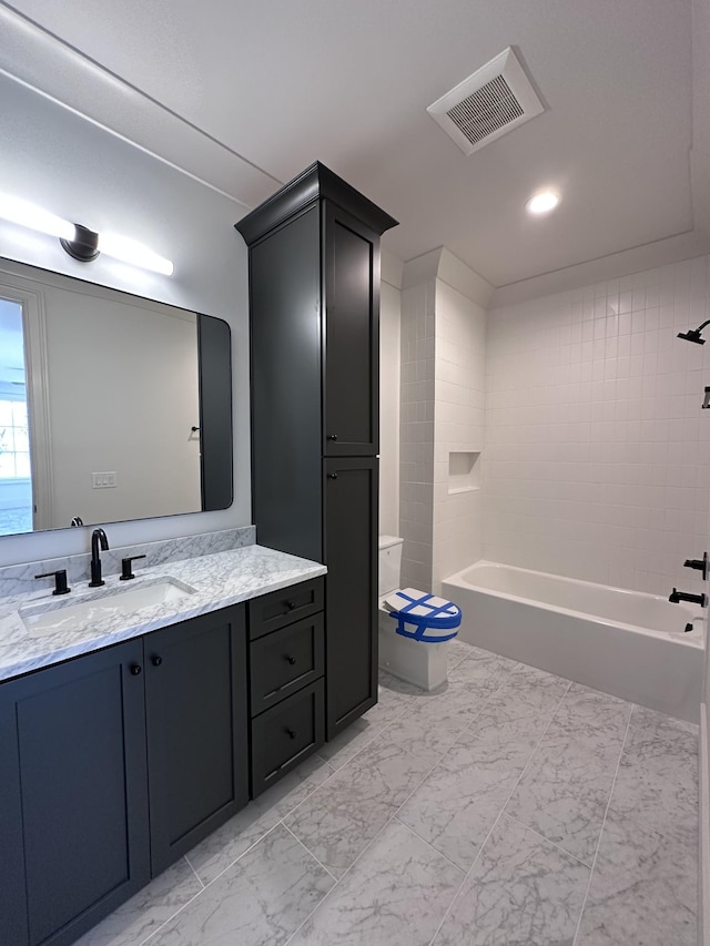 full bathroom with tiled shower / bath combo, vanity, and toilet