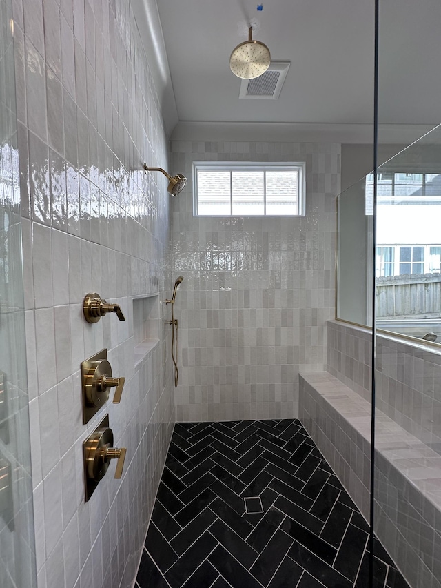 bathroom featuring ornamental molding and tiled shower