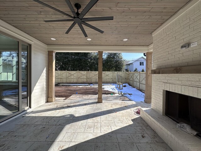 view of patio / terrace featuring ceiling fan and an outdoor brick fireplace