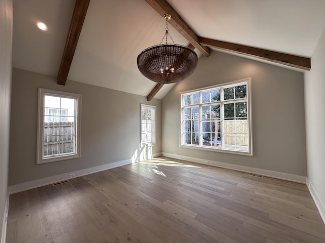 unfurnished room with a wealth of natural light, light hardwood / wood-style flooring, and lofted ceiling with beams