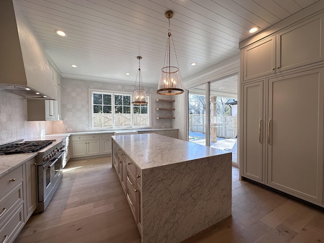 kitchen featuring double oven range, island range hood, backsplash, pendant lighting, and a center island