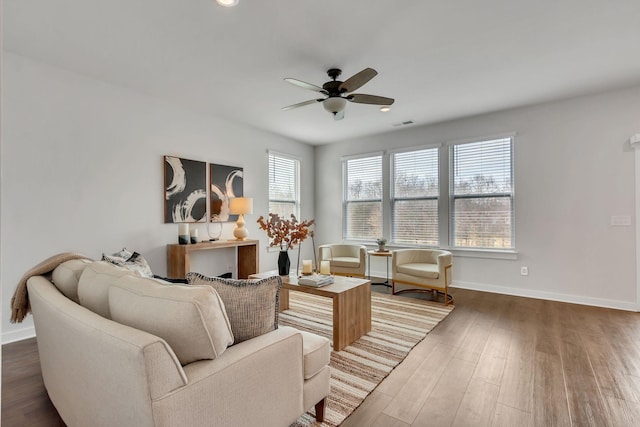 living room with ceiling fan and dark wood-type flooring