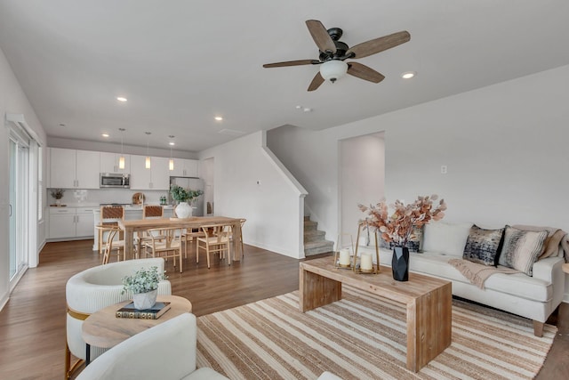 living room featuring wood-type flooring and ceiling fan