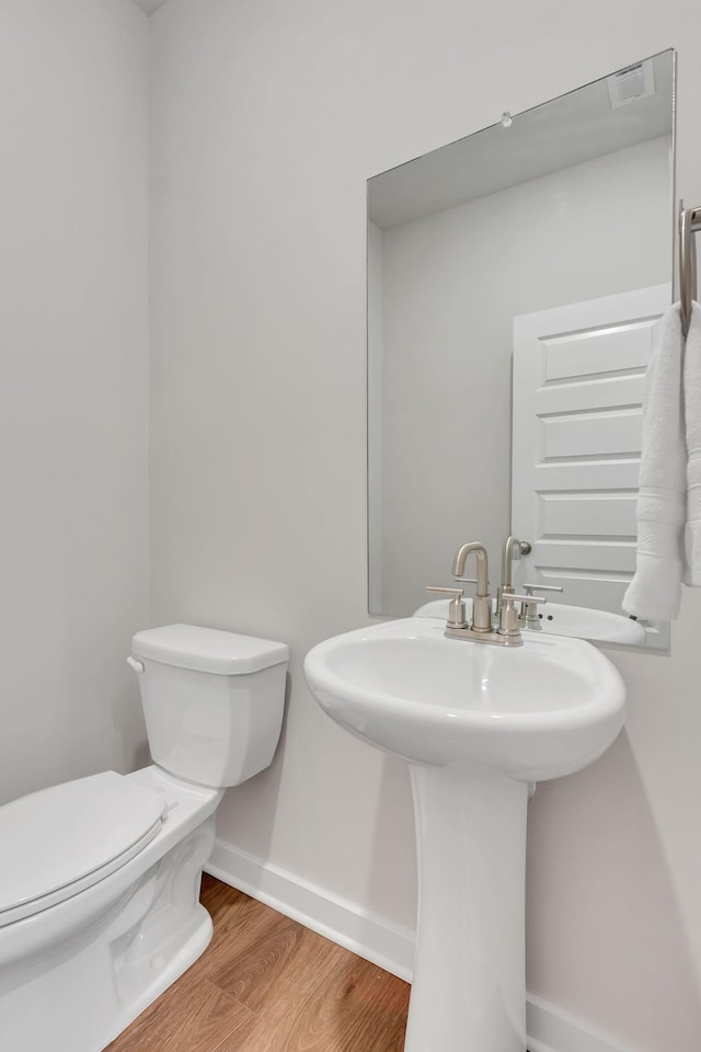 bathroom with hardwood / wood-style floors, toilet, and sink