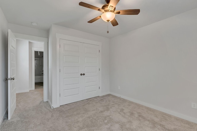 unfurnished bedroom with a closet, ceiling fan, and light colored carpet