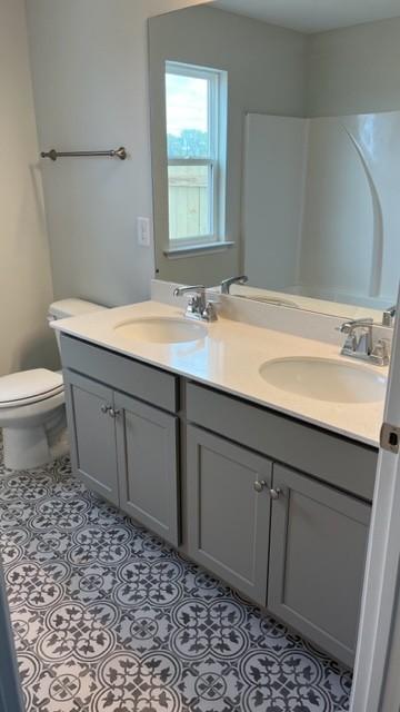 bathroom with tile patterned flooring, vanity, and toilet