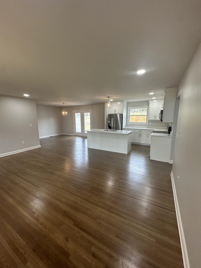 unfurnished living room featuring dark hardwood / wood-style flooring and a notable chandelier