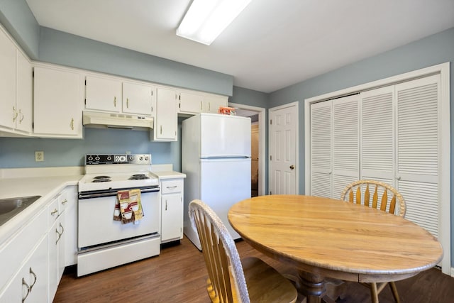 kitchen featuring dark hardwood / wood-style flooring, white appliances, and white cabinetry