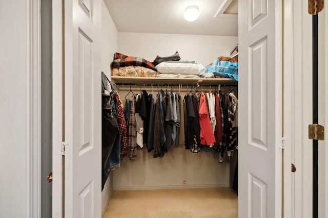 walk in closet featuring light colored carpet