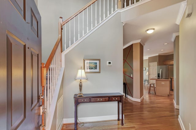 entryway featuring crown molding and hardwood / wood-style floors