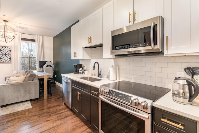 kitchen with white cabinets, hanging light fixtures, sink, and appliances with stainless steel finishes