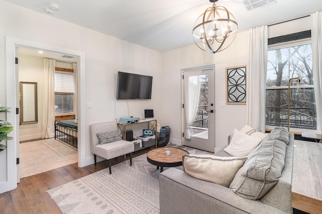 living room featuring wood-type flooring and a notable chandelier