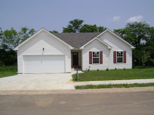 ranch-style home with a garage and a front yard