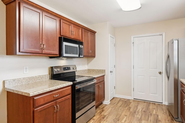 kitchen featuring stainless steel appliances and light hardwood / wood-style floors