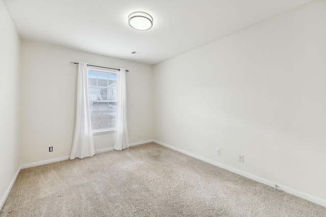 unfurnished room featuring light carpet