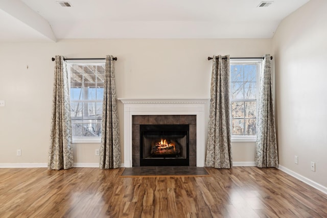 interior details with a tiled fireplace and hardwood / wood-style floors