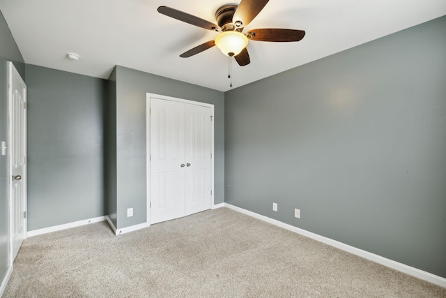 unfurnished bedroom featuring ceiling fan, light colored carpet, and a closet