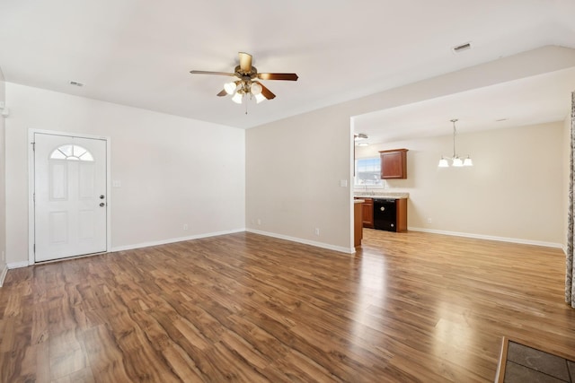 unfurnished living room featuring hardwood / wood-style floors, ceiling fan with notable chandelier, and sink