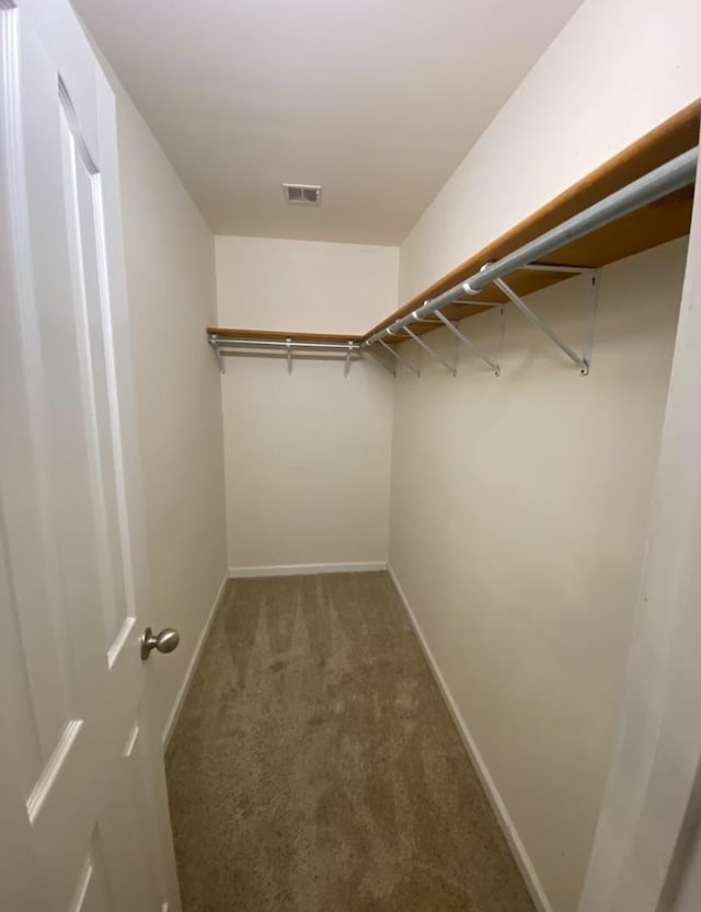 walk in closet featuring dark carpet