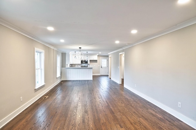 unfurnished living room with a chandelier, dark hardwood / wood-style floors, and ornamental molding