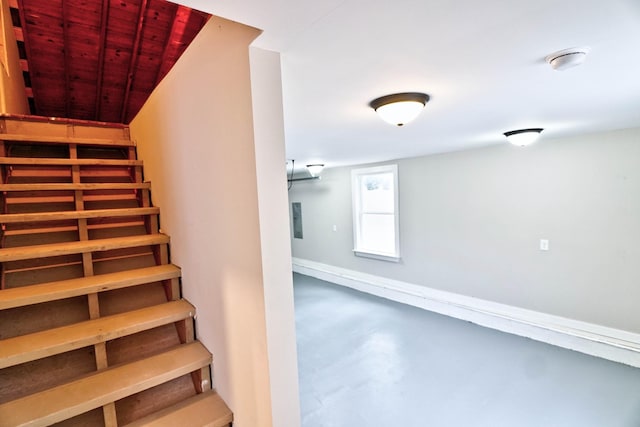 stairway with wooden ceiling and concrete floors