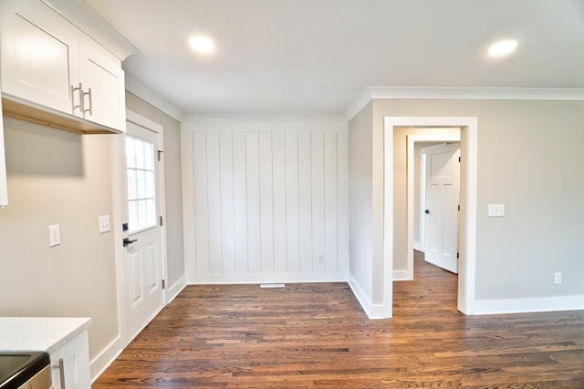 unfurnished dining area with dark hardwood / wood-style flooring and ornamental molding