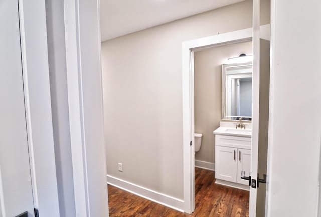 bathroom with hardwood / wood-style floors, vanity, and toilet