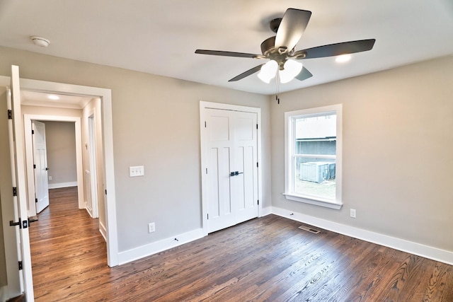 unfurnished bedroom with ceiling fan and dark wood-type flooring