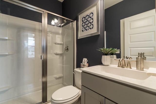 bathroom featuring vanity, toilet, and a shower with shower door