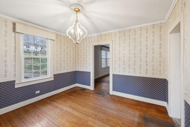 unfurnished dining area with a chandelier, hardwood / wood-style flooring, and crown molding