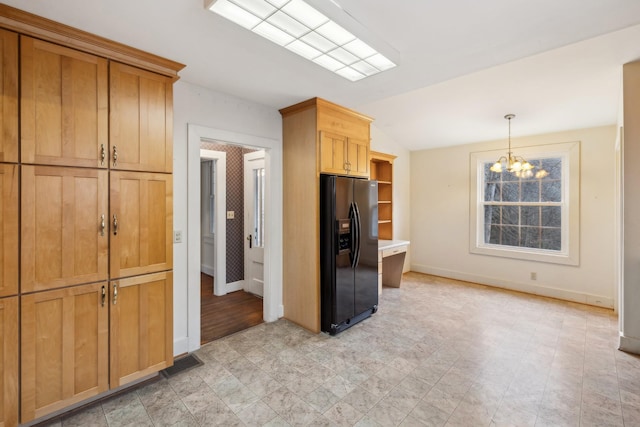 kitchen featuring vaulted ceiling, black fridge, decorative light fixtures, and an inviting chandelier