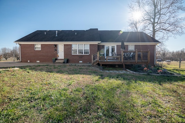 rear view of house with french doors, a deck, and a lawn