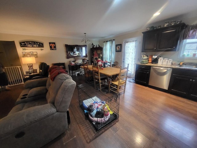 living room featuring a notable chandelier, wood-type flooring, and crown molding