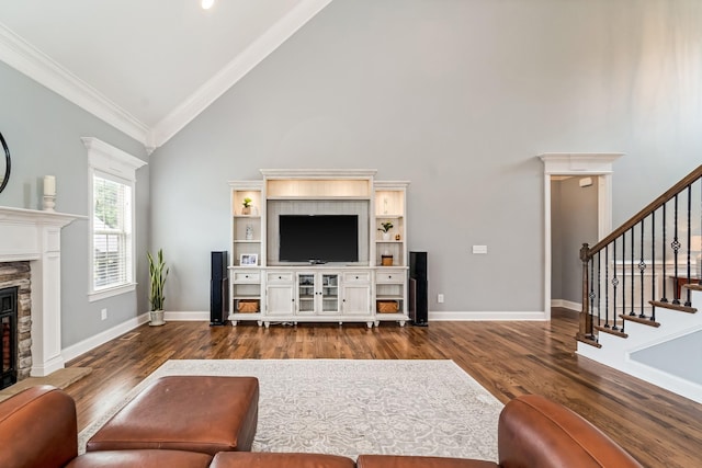 living room with dark hardwood / wood-style flooring, crown molding, a fireplace, and high vaulted ceiling