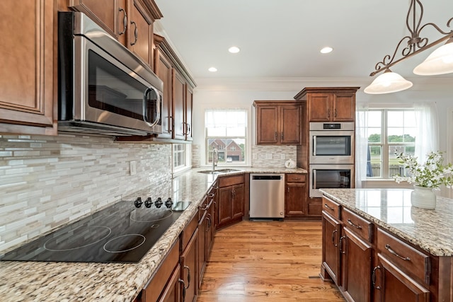 kitchen featuring pendant lighting, sink, tasteful backsplash, light stone counters, and stainless steel appliances