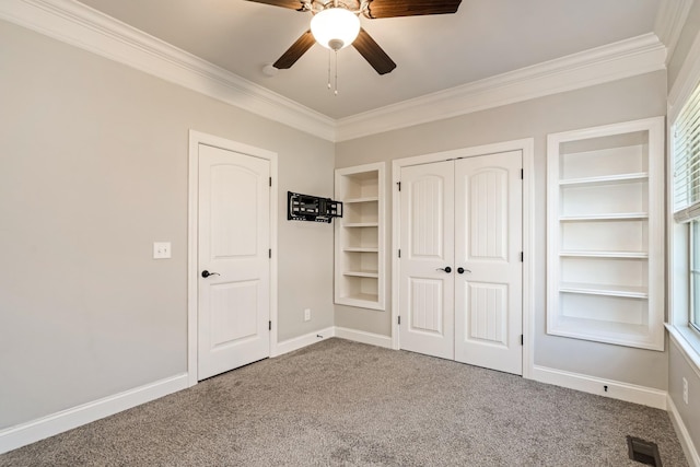 unfurnished bedroom featuring carpet, ceiling fan, crown molding, and a closet