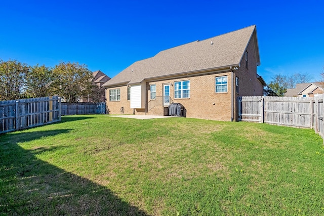 rear view of property featuring a yard and a patio area