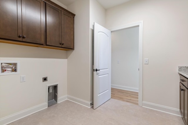 washroom with electric dryer hookup, hookup for a washing machine, light tile patterned floors, and cabinets