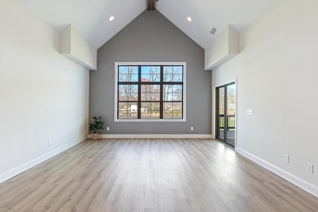 unfurnished living room featuring light hardwood / wood-style floors, beam ceiling, and high vaulted ceiling