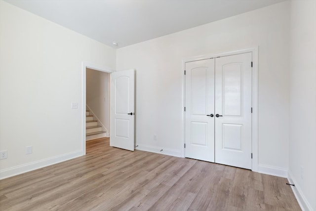 unfurnished bedroom featuring light hardwood / wood-style flooring and a closet