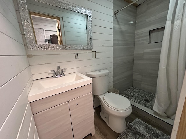 bathroom featuring a shower with curtain, vanity, toilet, and wooden walls