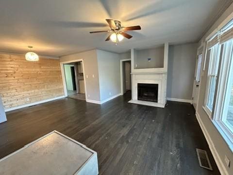 unfurnished living room with visible vents, a fireplace, baseboards, and wood finished floors