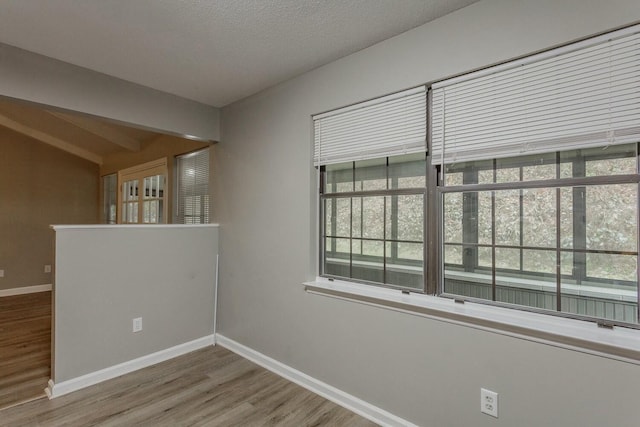 unfurnished room featuring hardwood / wood-style floors and a textured ceiling