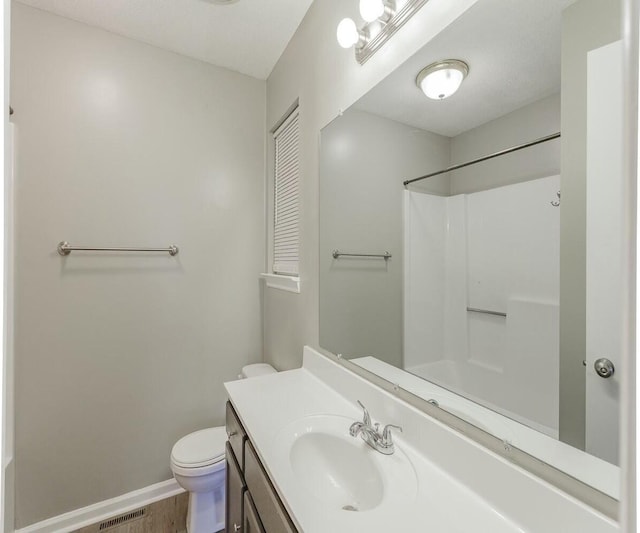 bathroom with vanity, toilet, wood-type flooring, and a shower